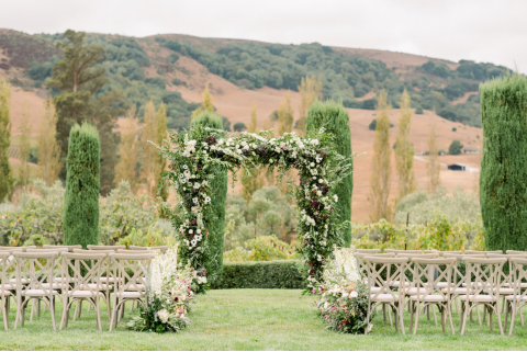A floral ceremony arch set at a destination wedding.