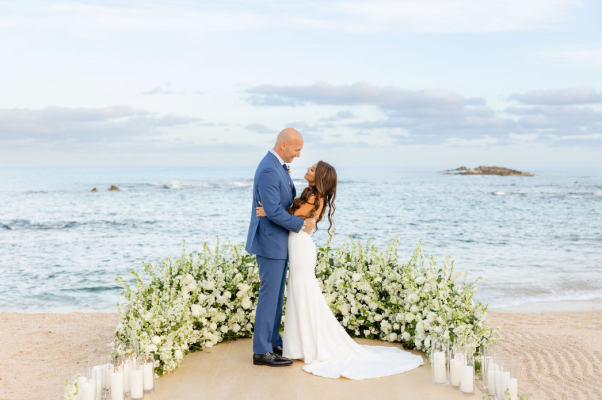 A newly married couple shares an intimate moment by the beach