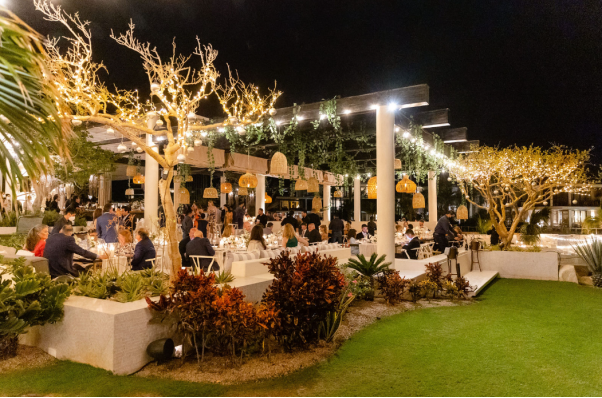 A luxurious outdoor reception under glowing lights and lush greenery