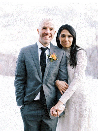A couple poses for a picture at their wedding.