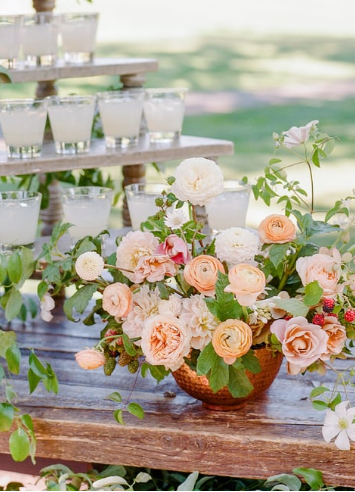 A floral arrangement next to a refreshing drink setup.