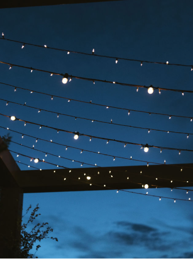 A string of yellow lights shown against the dark blue sky at a luxury wedding