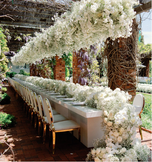 A large table adorned with white flowers at a luxury wedding