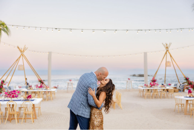 A couple shares an intimate moment at their vibrant beachfront reception in Puerto Vallarta