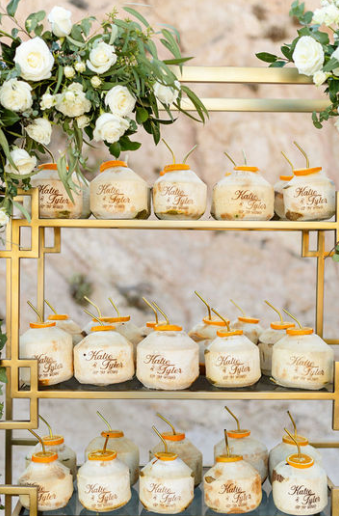 A custom wedding drink stand with several coconuts arranged uniformly.