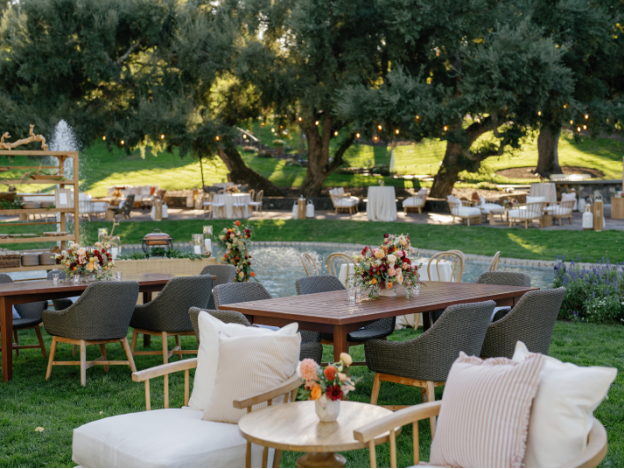 A garden with tables and chairs set up for a luxury wedding