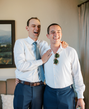 The best man and groom share a laugh while preparing for the ceremony.