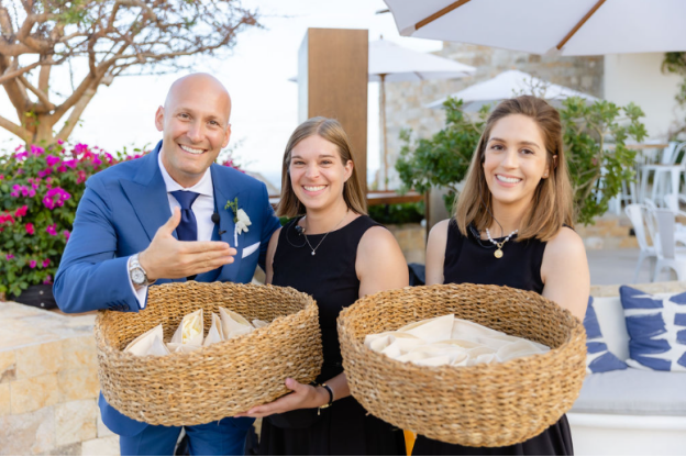 A groom and his friends are presenting customized welcome gifts to the guests.