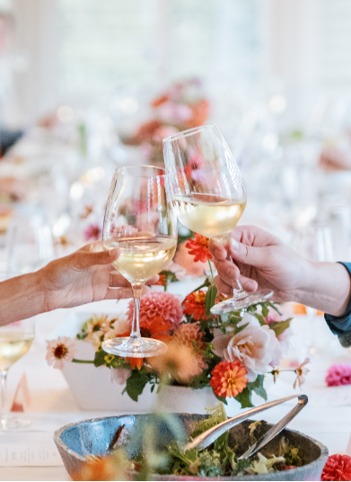 Table décor with elegant florals and clinking glasses at a luxury wedding reception dinner