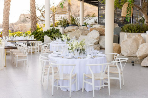 Intimate outdoor wedding setup with white floral centerpieces and serene rock garden views in Cabo