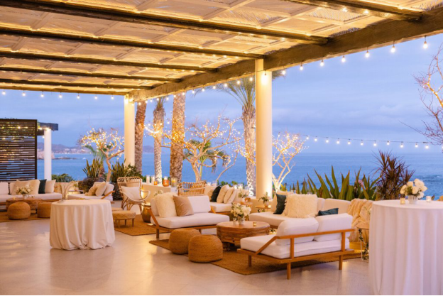 Cozy lounge seating under twinkling lights overlooking the ocean