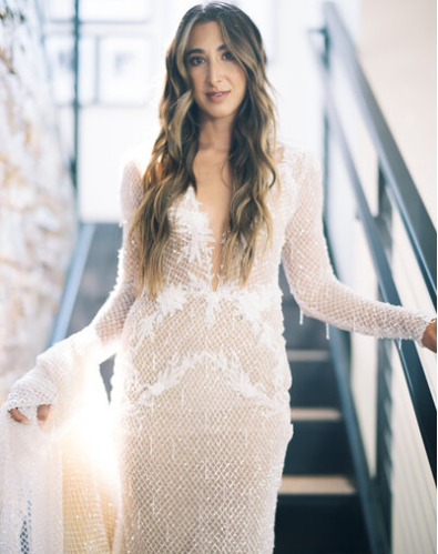 Bride wearing a shimmering couture gown with intricate detailing, standing gracefully on a staircase