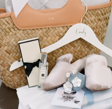 A beautifully arranged personalized welcome bag featuring perfume, elegant shoes, sparkling earrings, and other luxury essentials