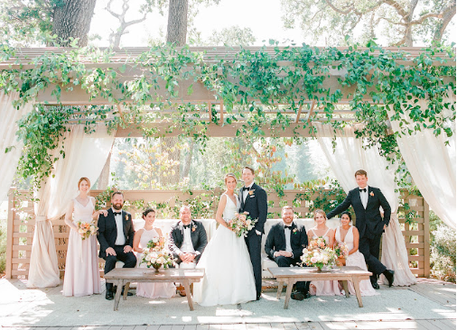 Wedding guests posing against a picturesque backdrop, with elegant décor and warm ambient lighting enhancing the scene.