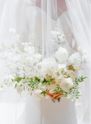 A bride elegantly holding a flower bouquet, capturing the beauty and emotion of her wedding day.