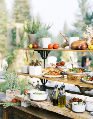 A rustic food station with charcuterie and fresh ingredients.