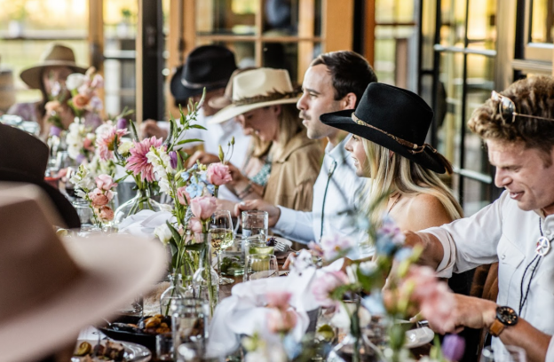 Guests enjoying food and conversation at an outdoor welcome party.