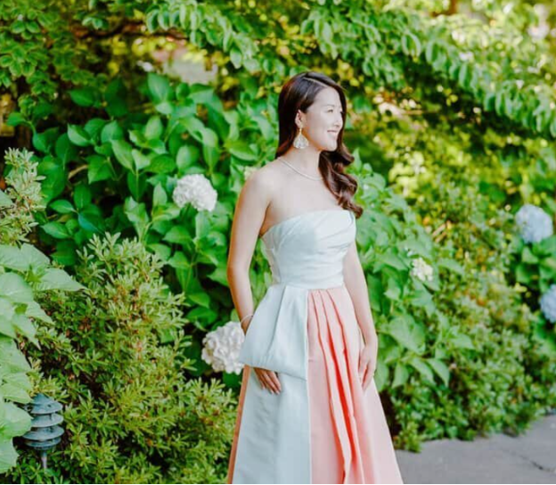 A white and pink bridal after-party dress displayed on a hanger.