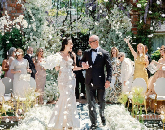 A bride walking down the aisle in a lace wedding gown
