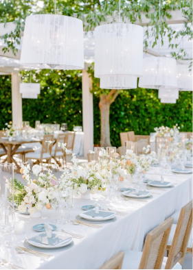 Elegant wedding table decor with fine linens, florals, and candlelight in a summer setting.