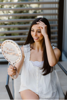 The bride is looking at herself in the mirror.