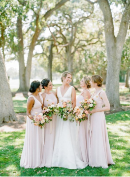 A bride posing with her bridesmaids.