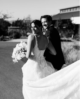Joyful bride and groom walking post-ceremony, captured in candid black-and-white