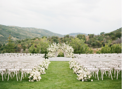 An image of chairs and an altar decorated with white flowers 
