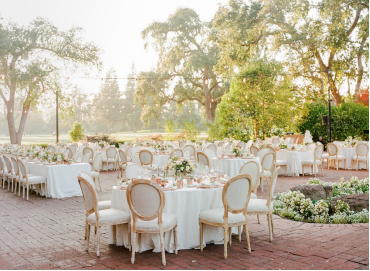 An image of floral arrangements on tables during a wedding set up outdoors 