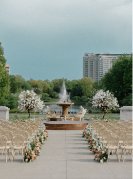 Elegant outdoor wedding ceremony setup in Chicago with a fountain, floral arrangements, and rows of guest chairs.