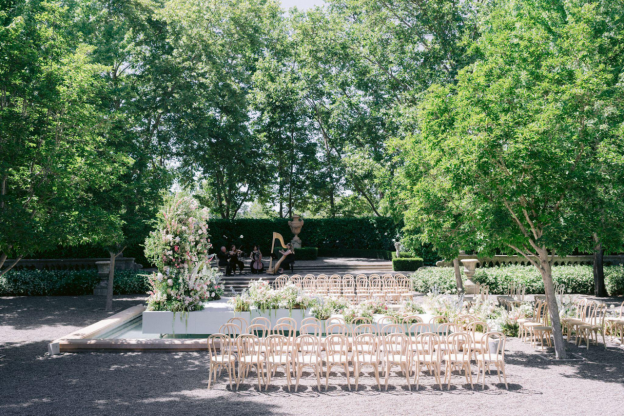 Outdoor wedding ceremony setup with white chairs arranged outdoors
