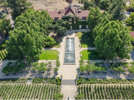 Aerial view of wedding venue with vineyard, fountain, and estate building