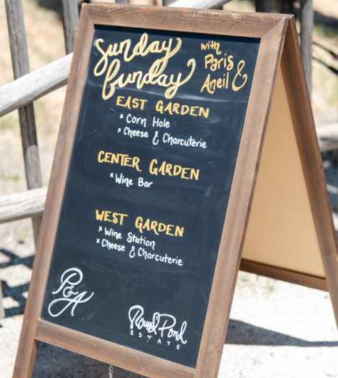 Chalkboard sign with Sunday Funday wedding event details for guests.