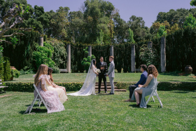 An image of a bride and groom standing at the altar with guests looking at them