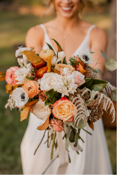  a bride in a white dress holding a wedding bouquet. 