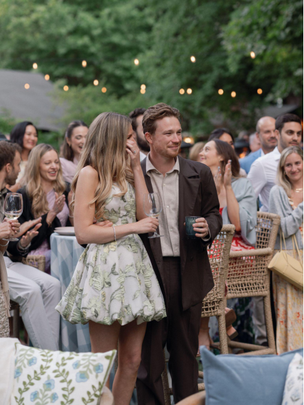 A bride and groom look emotional during speeches.