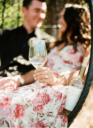 a bride holding a wine glass at her engagement shoot.