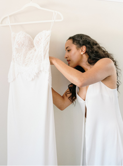 a bride looking at her wedding gown. 